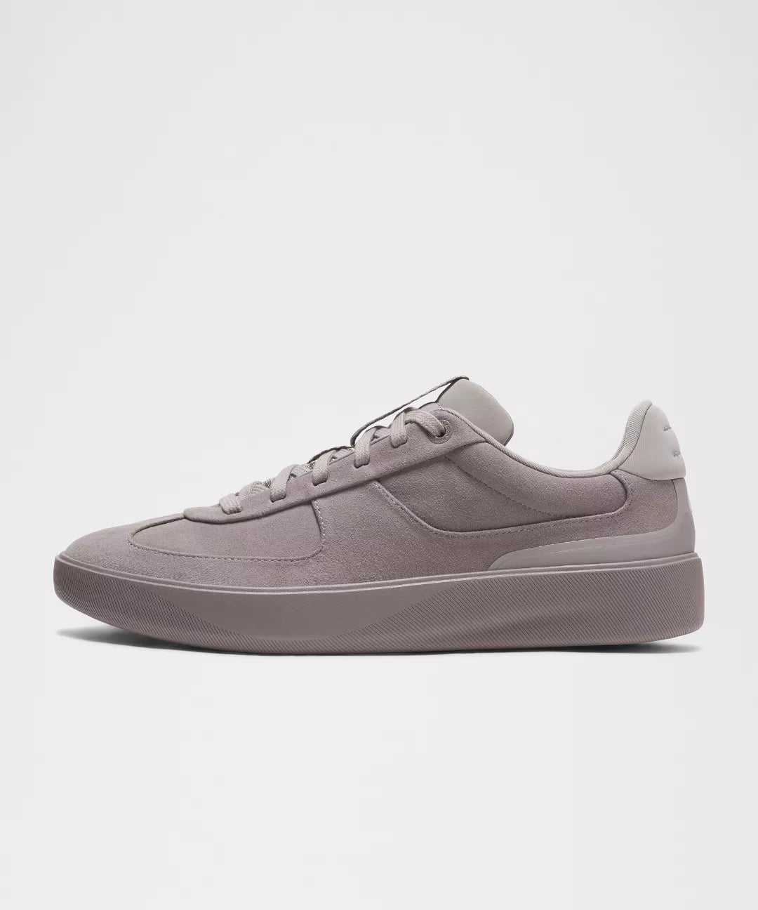 Black sneaker with white sole on a light gray background