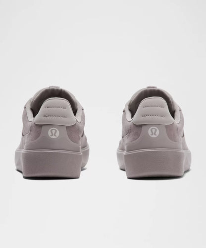 Gray sneakers with a visible brand logo on a light gray background