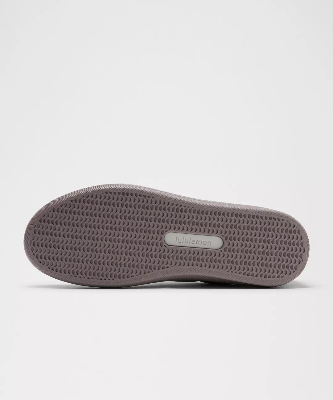 Gray sneaker sole with brand logo on a light gray background