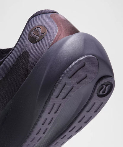 Close-up of a shoe with a focus on the sole and brand logo.