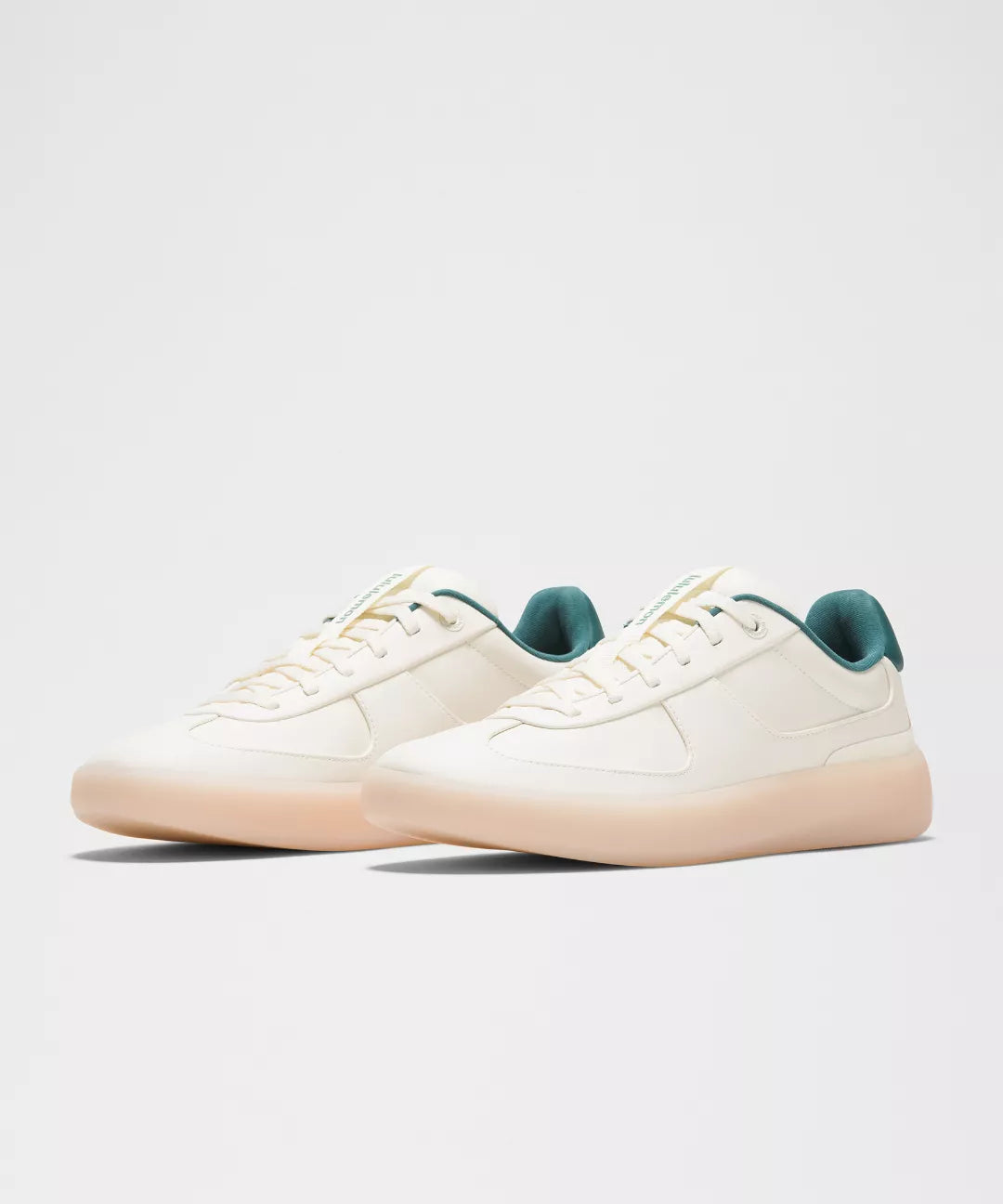 White sneakers with green accents on a light gray background
