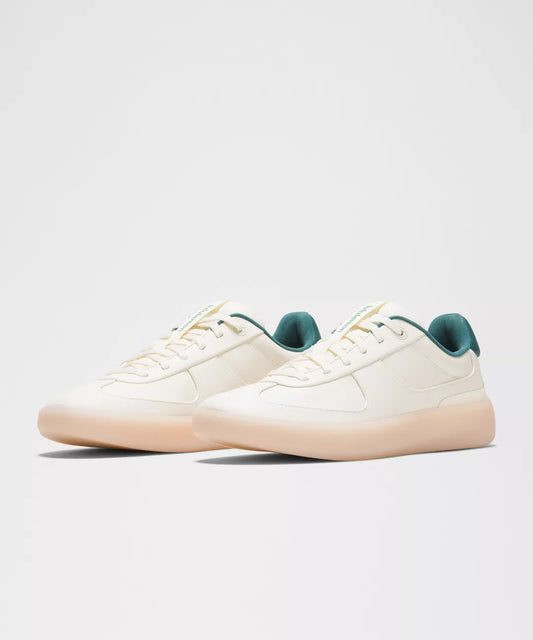 White sneakers with green accents on a light gray background