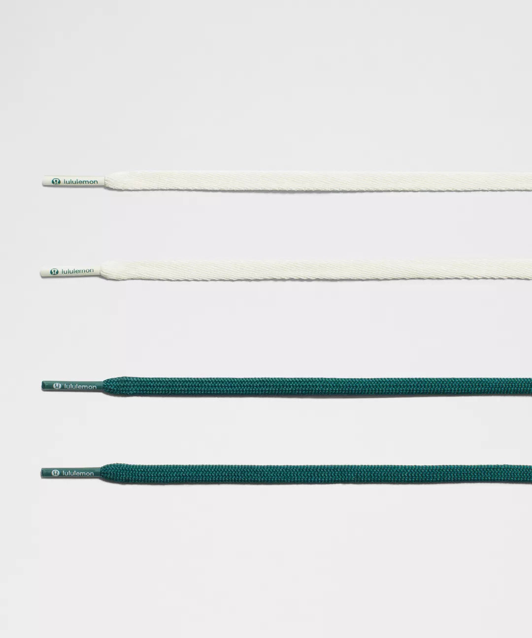 Set of white and green shoelaces on a light gray background