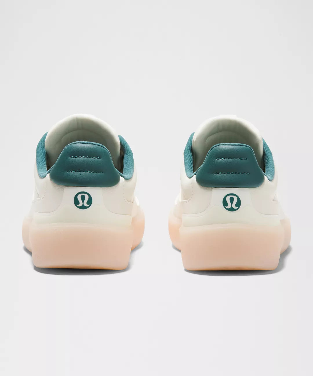 White sneakers with teal accents and a visible brand logo on a light gray background