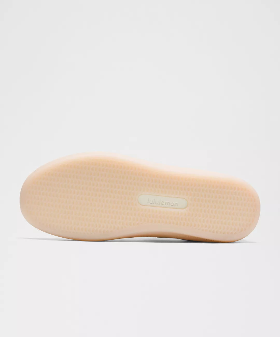 Beige shoe sole with a brand label on a light gray background