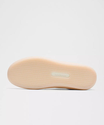 Beige shoe sole with a brand label on a light gray background