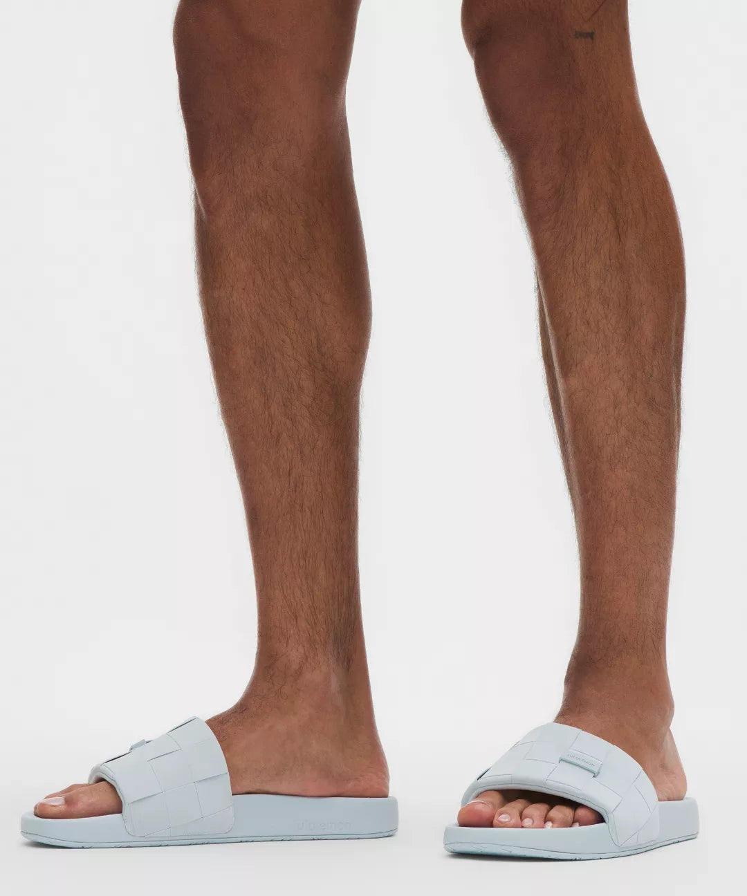 Light blue slides worn by a person on a white background