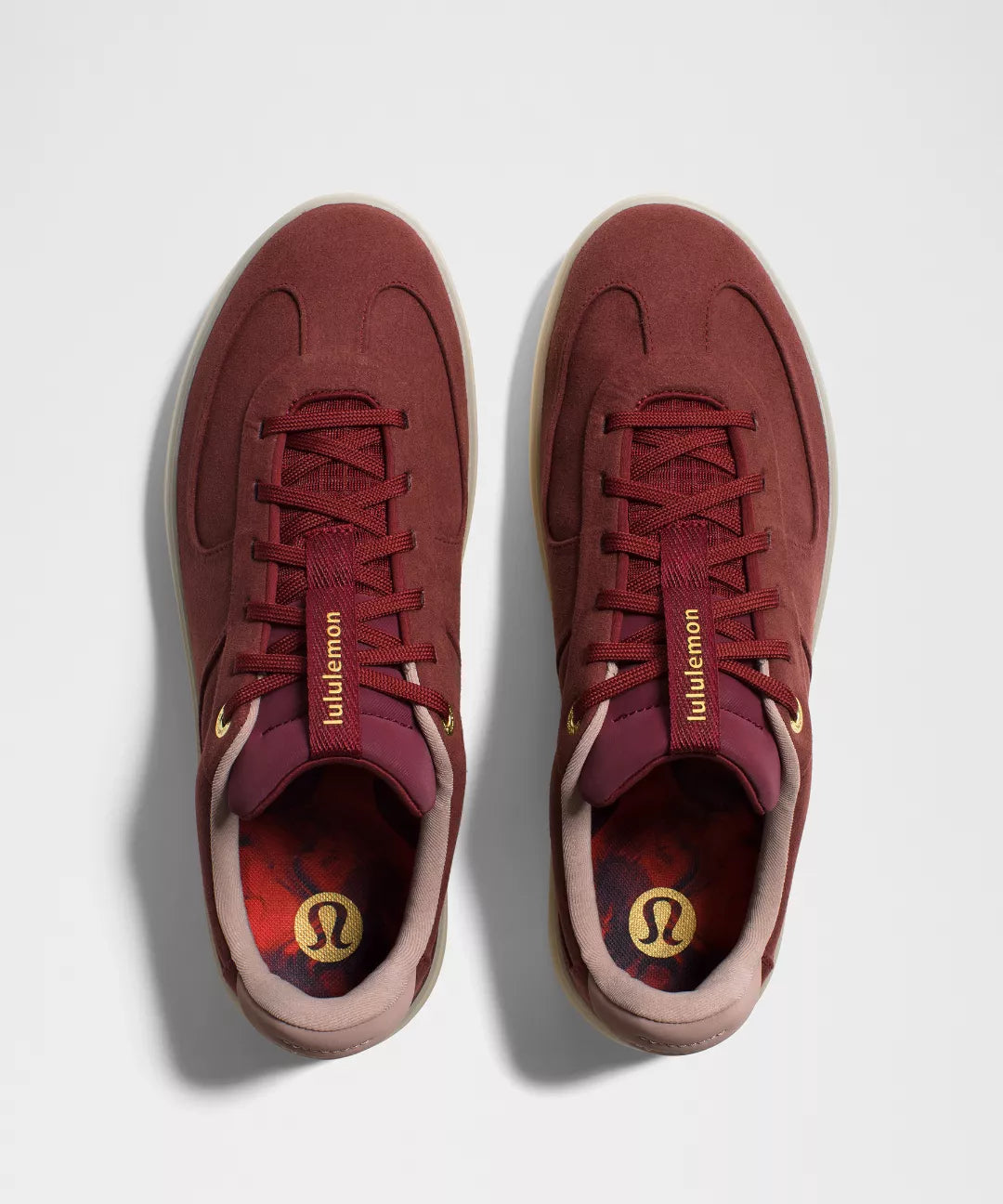 Maroon sneakers with visible Lululemon branding on a light gray background