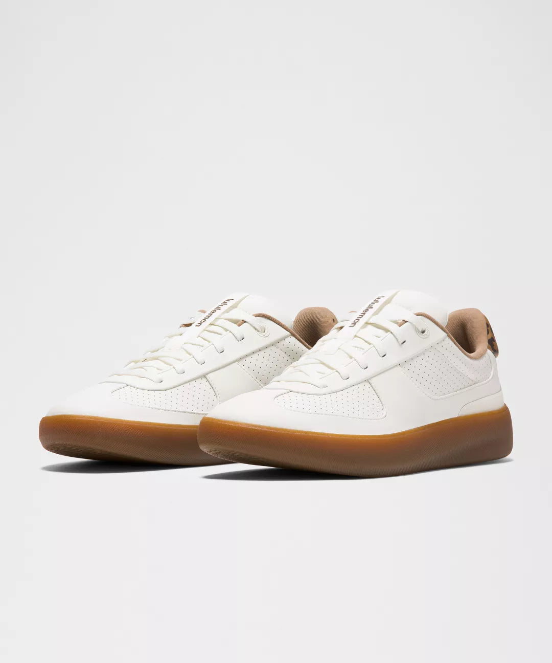 White sneakers with brown soles on a light gray background
