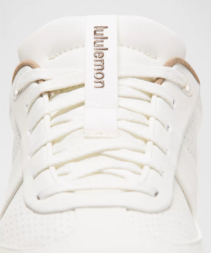 White sneaker with lulu lemon branding on a light gray background