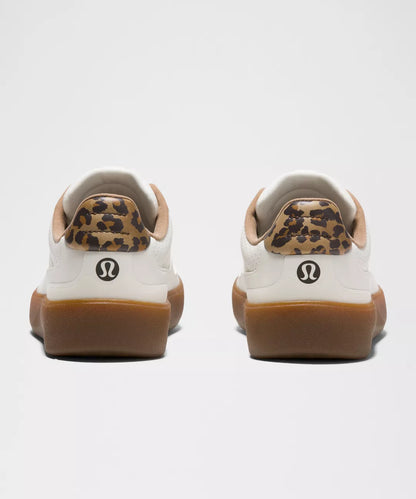 Pair of Lululemon sneakers with leopard print accents on a white background