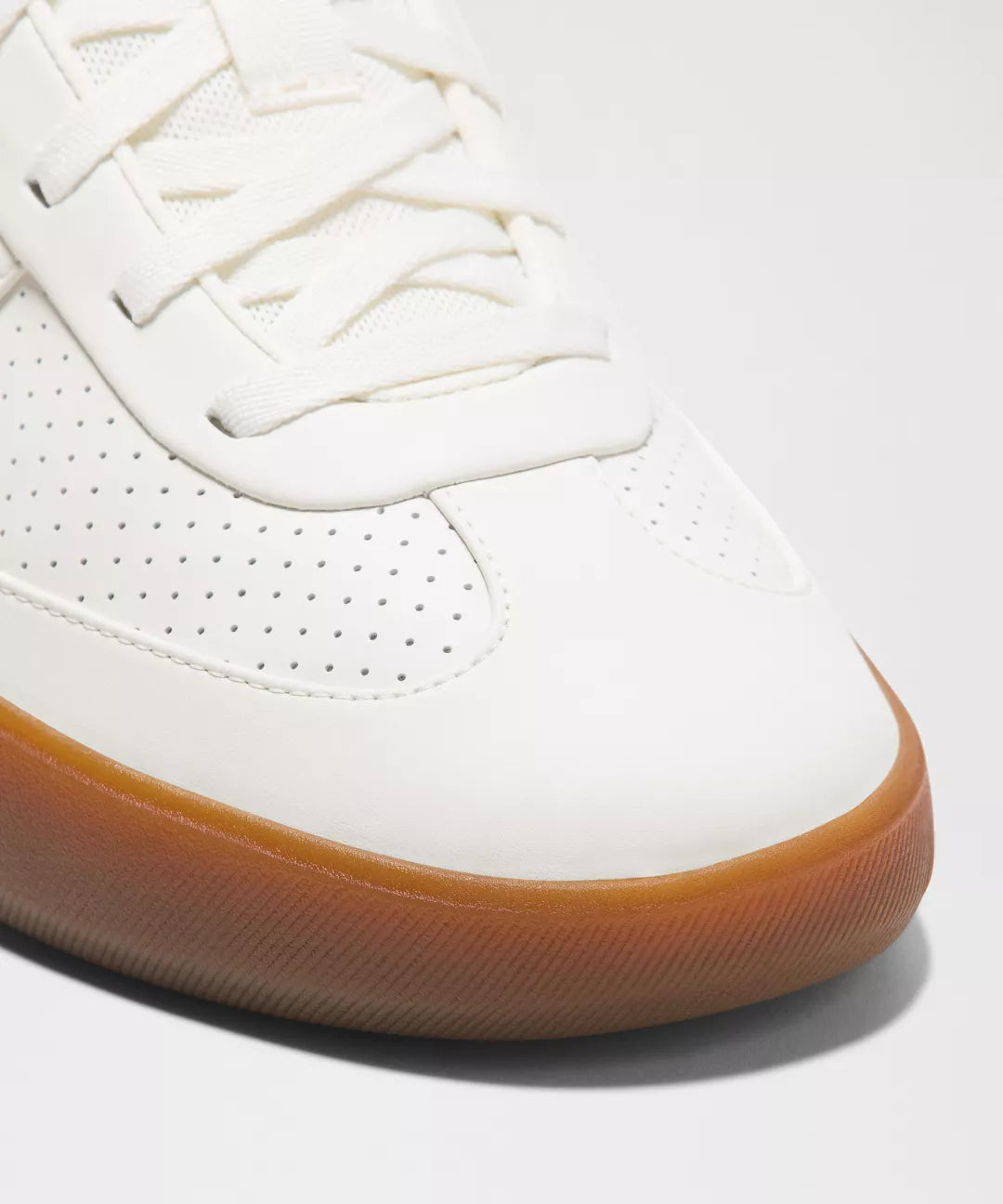 White sneaker with brown sole on a white background