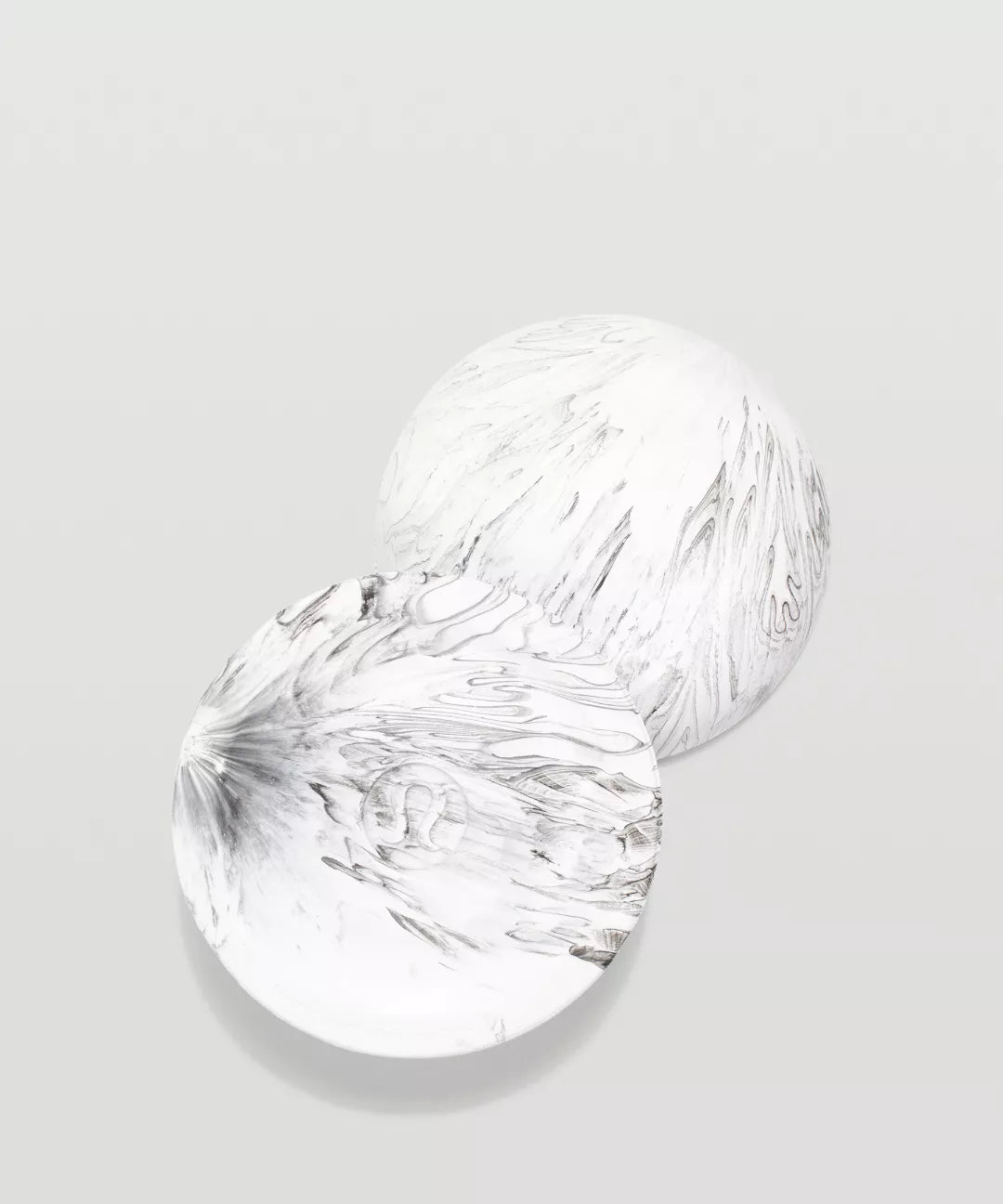 Two clear glass plates with textured surfaces on a light gray background
