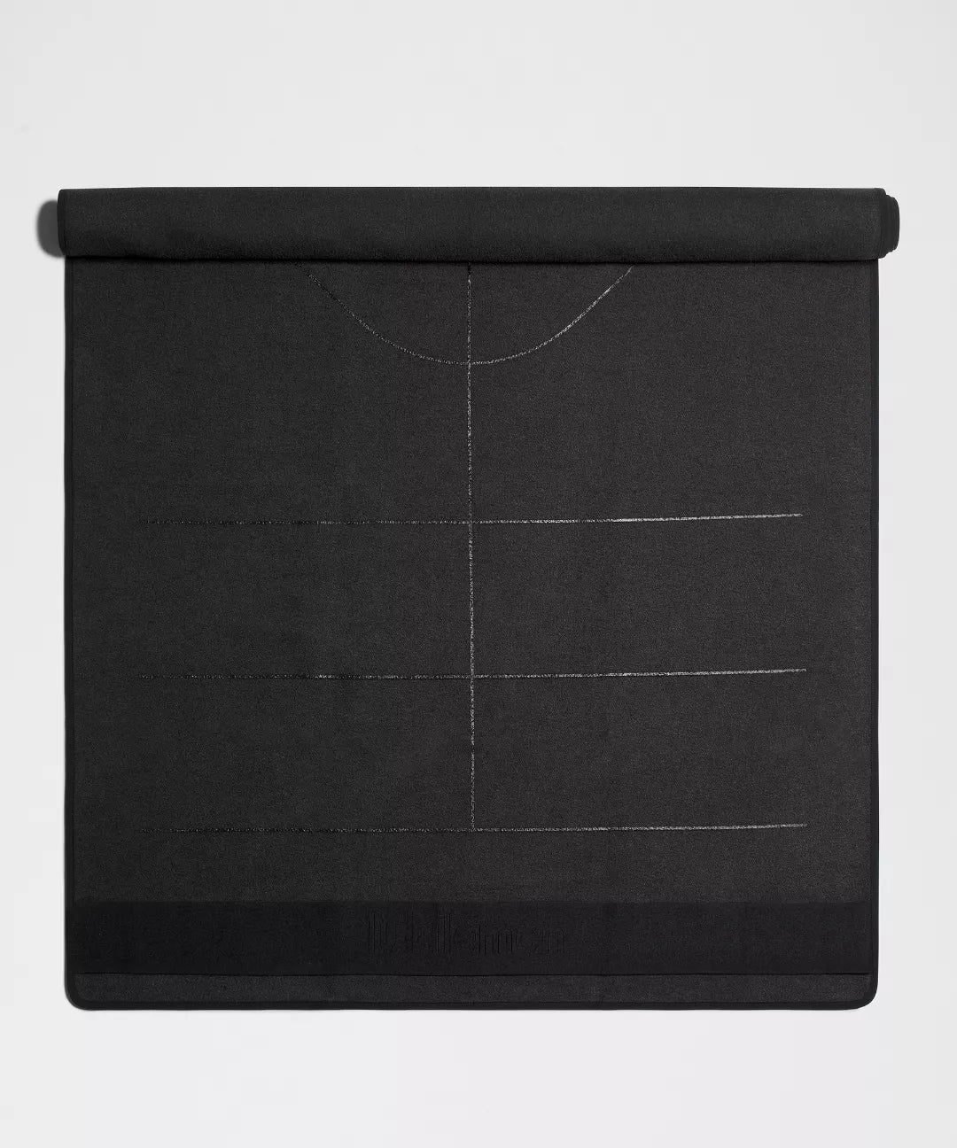 Black yoga mat with grid lines on a light gray background