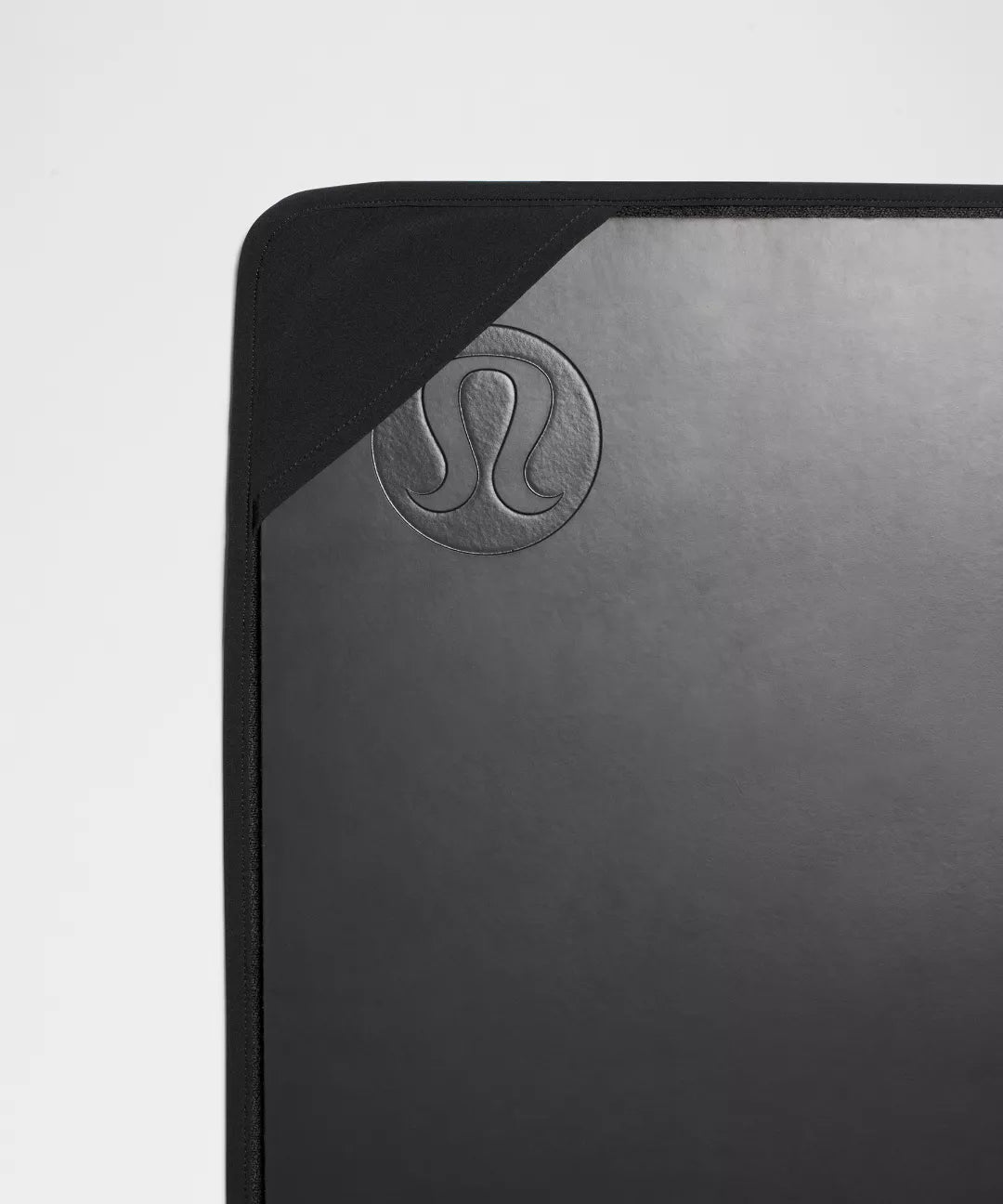 Black yoga mat with Lululemon logo on a light gray background