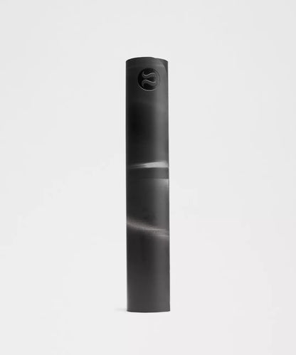 Rolled black yoga mat on a light gray background