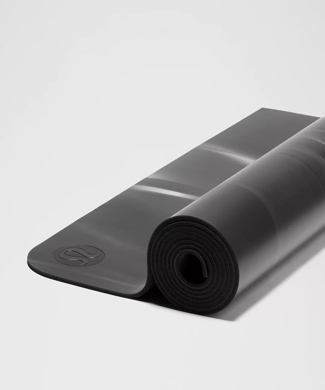 Rolling black yoga mat on a light gray background