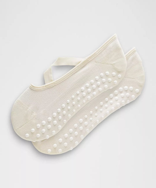 Pair of beige ankle socks with white dots on a light gray background