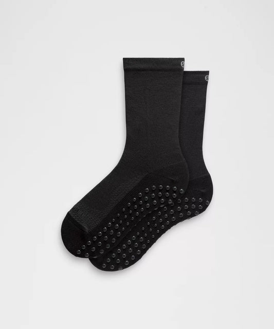 Two black socks with branding on a light gray background