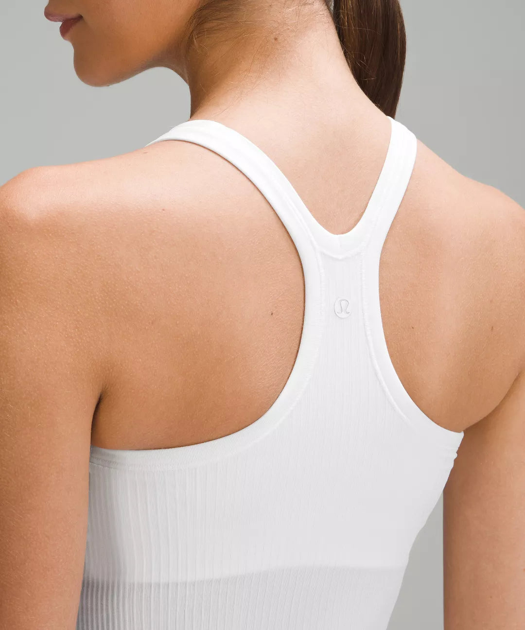 White tank top worn by a person on a gray background