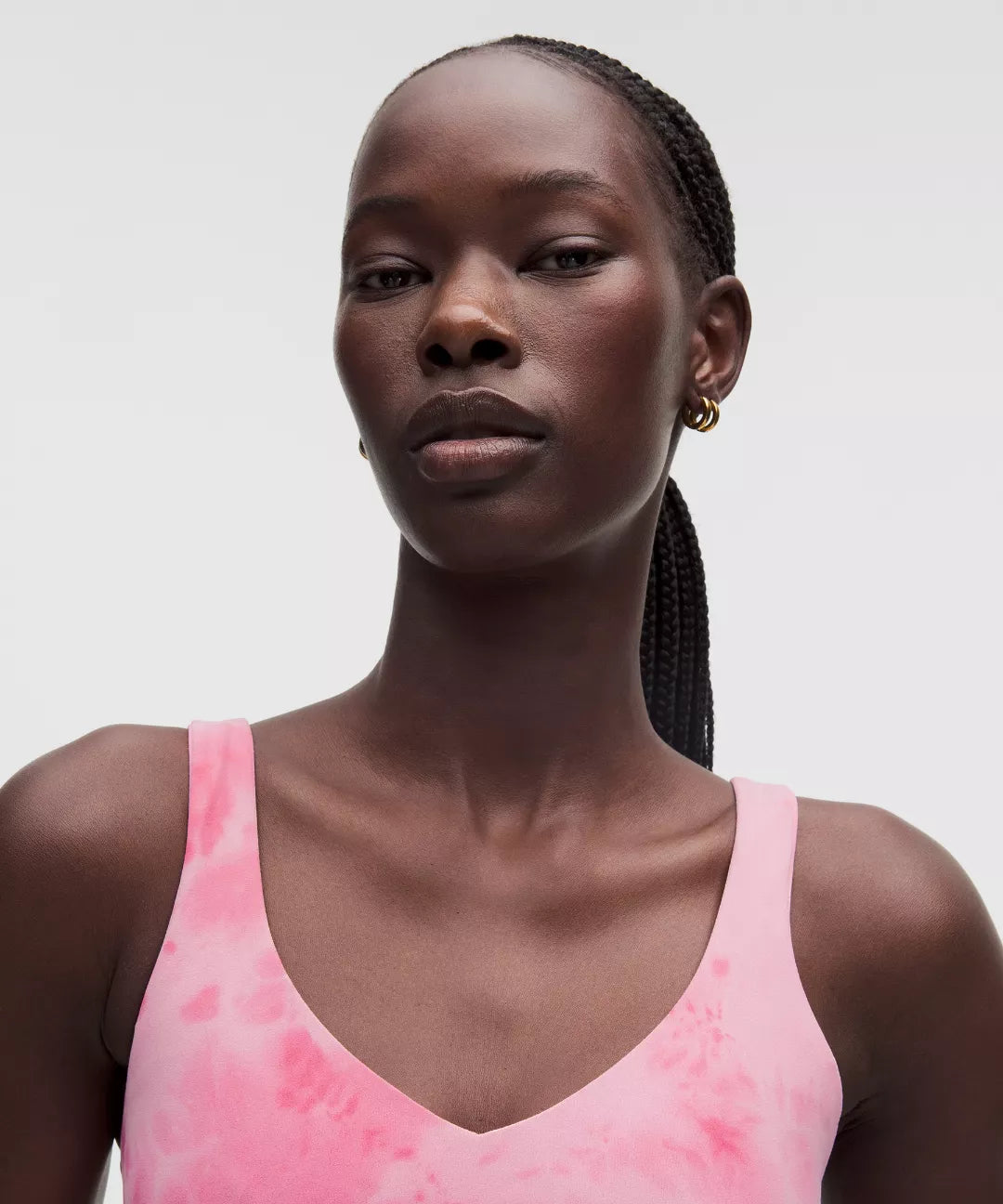Woman wearing a pink tank top against a plain background