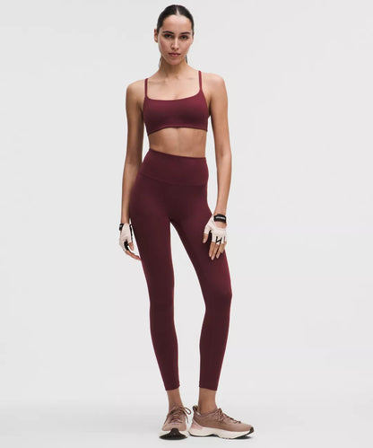 Woman wearing a maroon athletic outfit on a white background