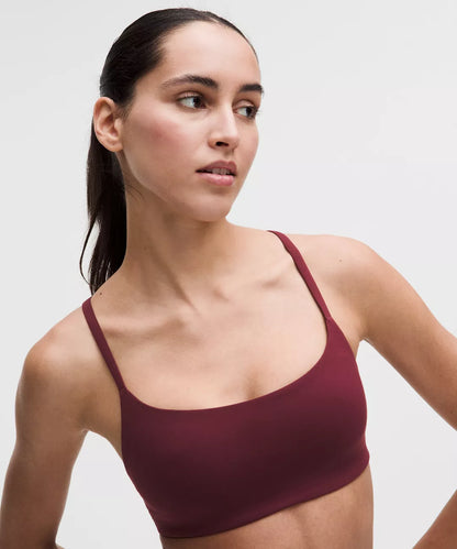Woman wearing a maroon sports bra against a plain background