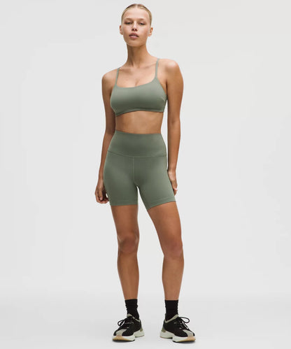 Woman wearing a green athletic outfit on a white background