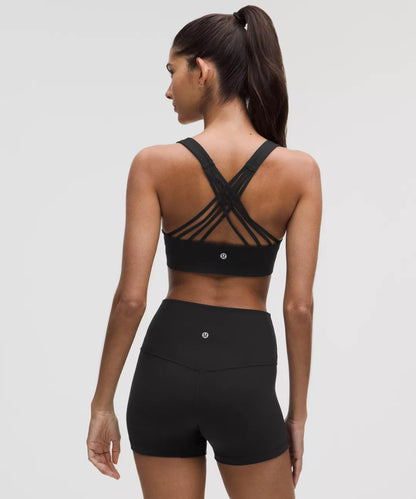Woman wearing a black sports bra and shorts set on a gray background