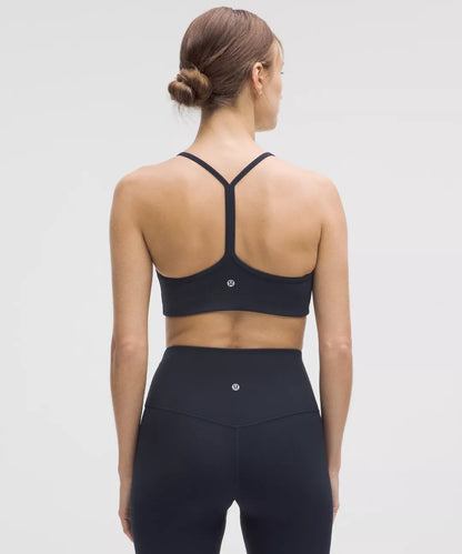 Person wearing a black sports bra and leggings on a light gray background