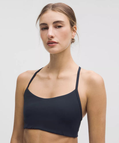 Woman wearing a black sports bra against a plain background
