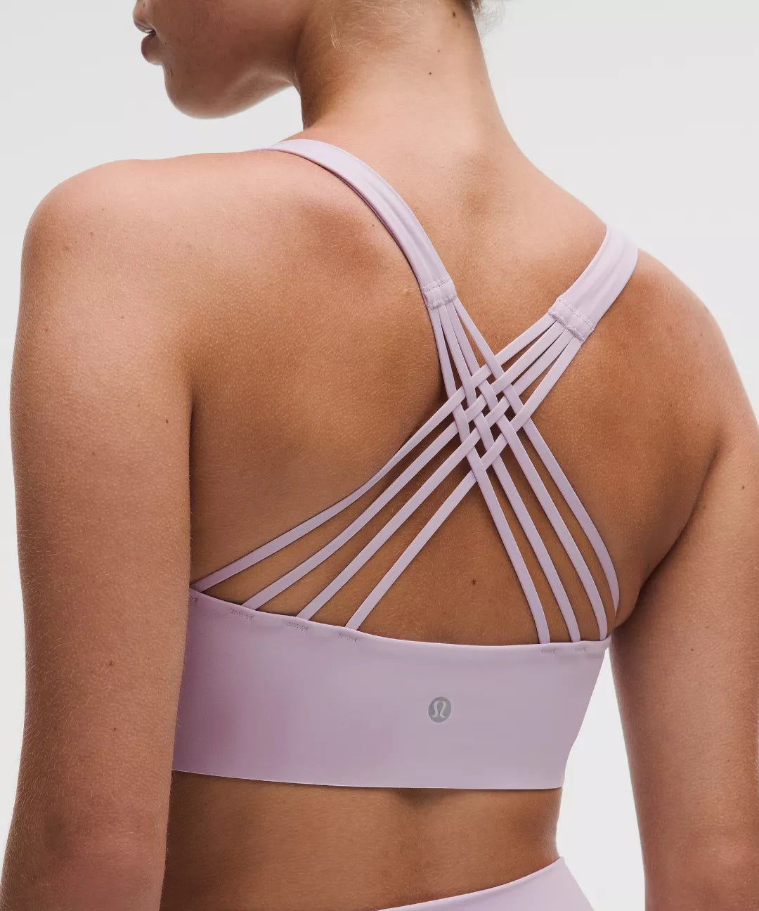 Lavender sports bra with criss-cross straps on a neutral background
