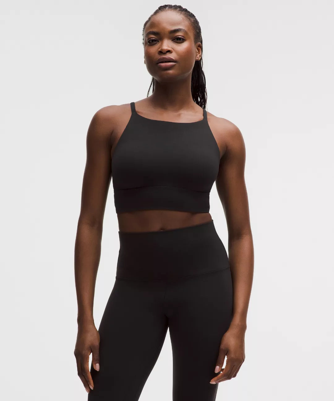 Woman wearing a black athletic outfit on a white background
