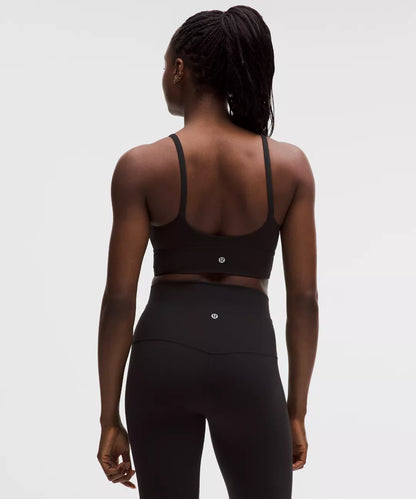 Person wearing a black sports bra and leggings on a white background