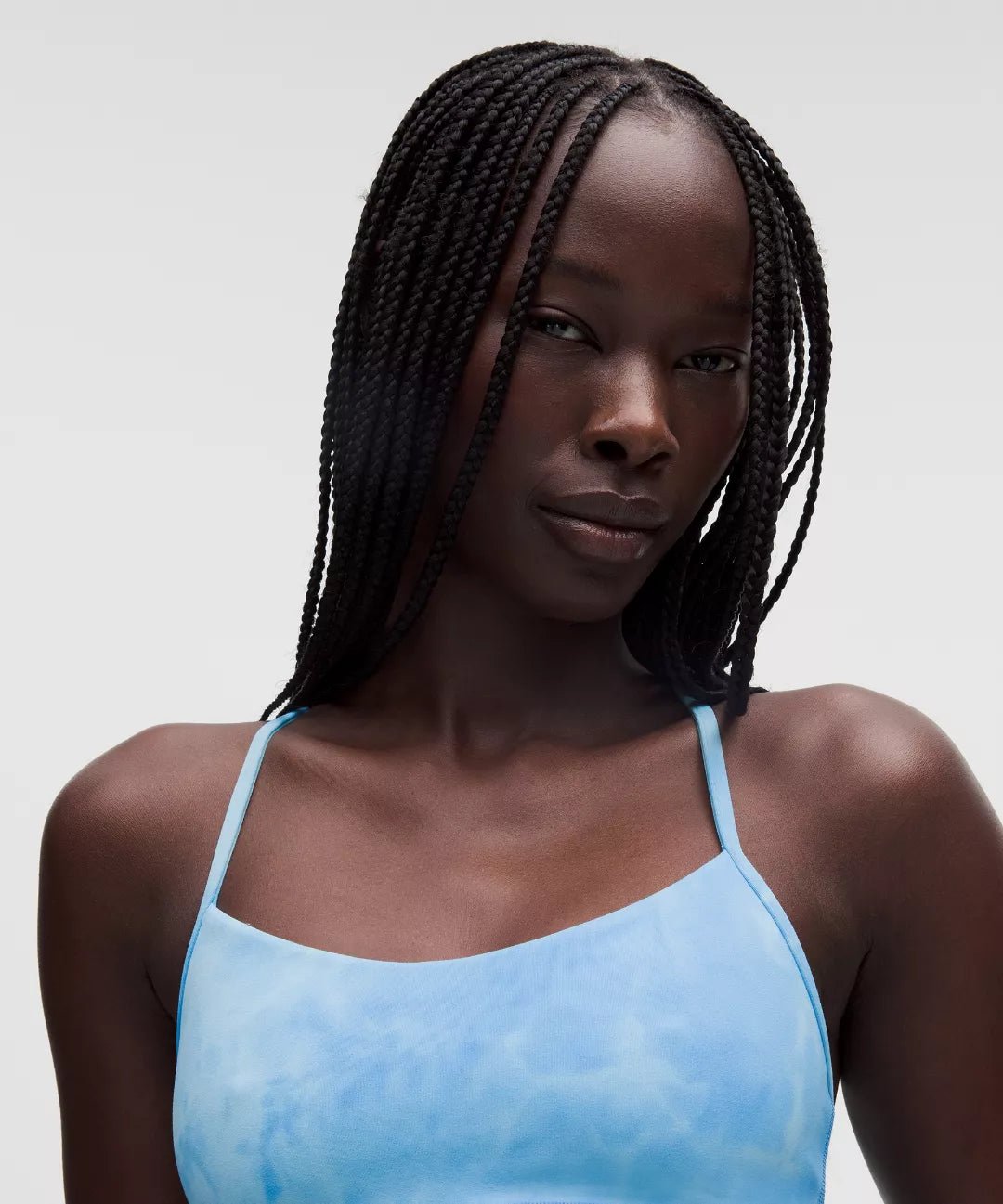 Woman wearing a light blue tank top against a plain background