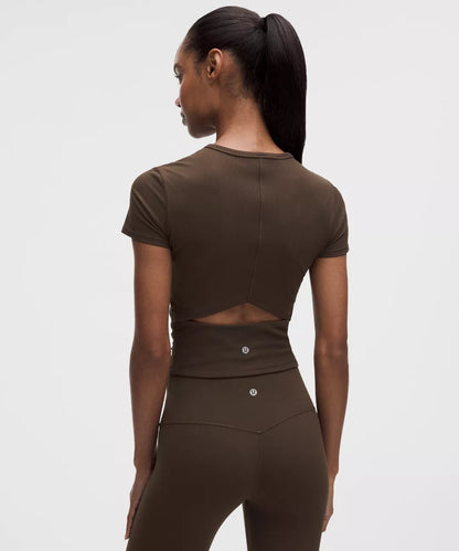 Woman wearing a brown athletic outfit on a white background