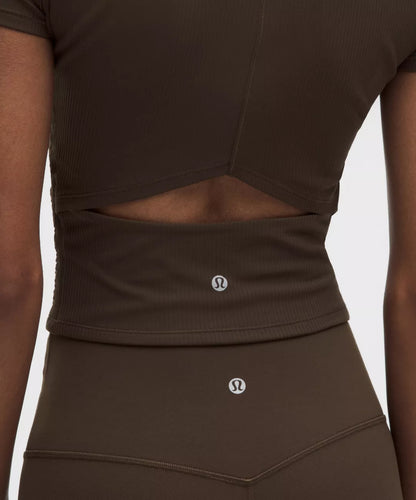 Brown athletic top and shorts with brand logo on a plain background
