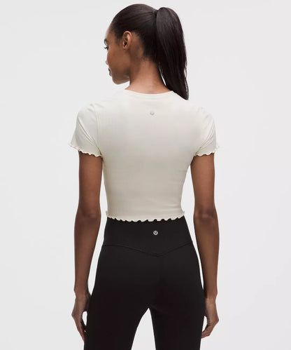 Person wearing a white top and black pants on a plain background