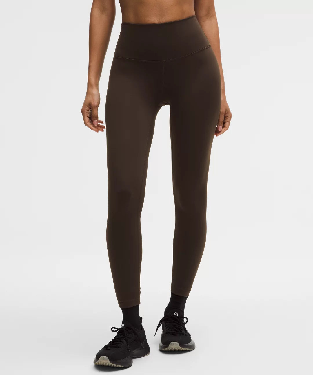 Person wearing brown leggings on a white background