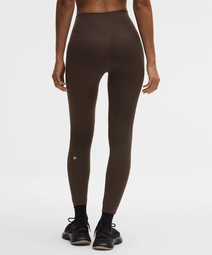 Brown leggings worn by a person on a white background