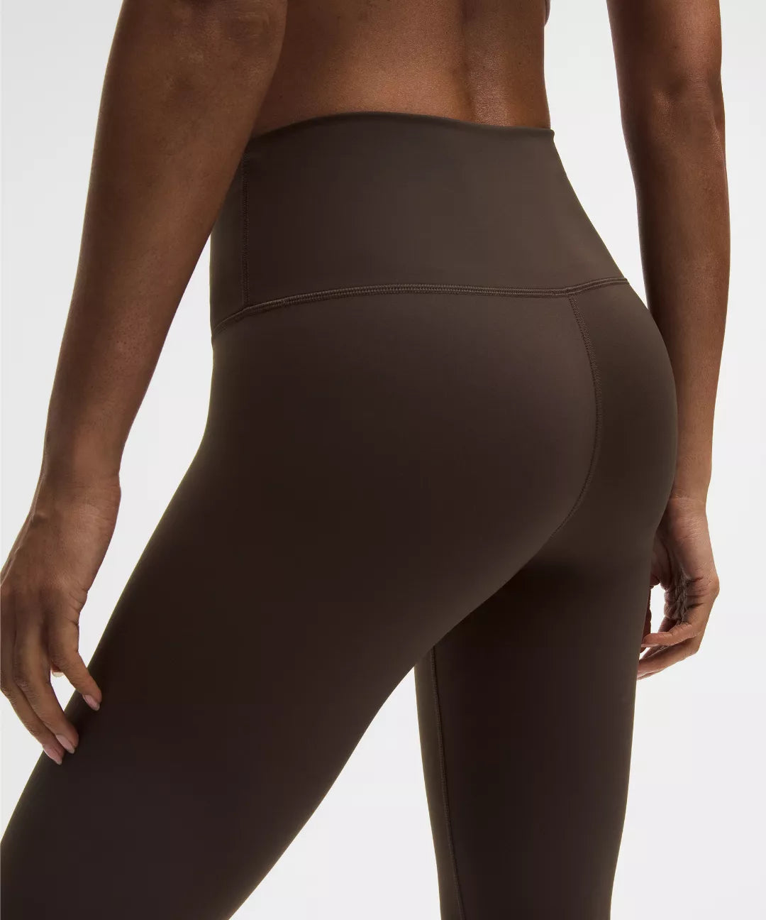 Brown leggings worn by a person on a white background