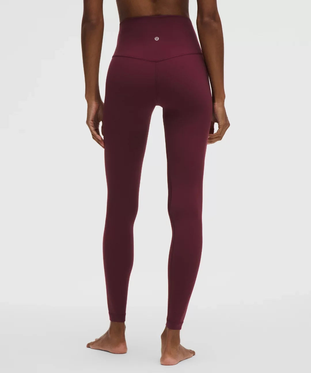 Maroon leggings worn by a person on a white background