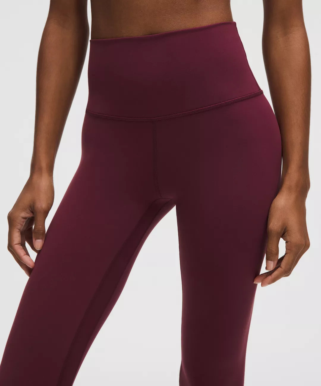 Maroon leggings worn by a person on a white background