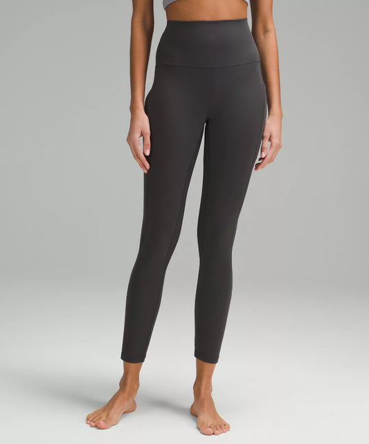 Person wearing black leggings on a gray background