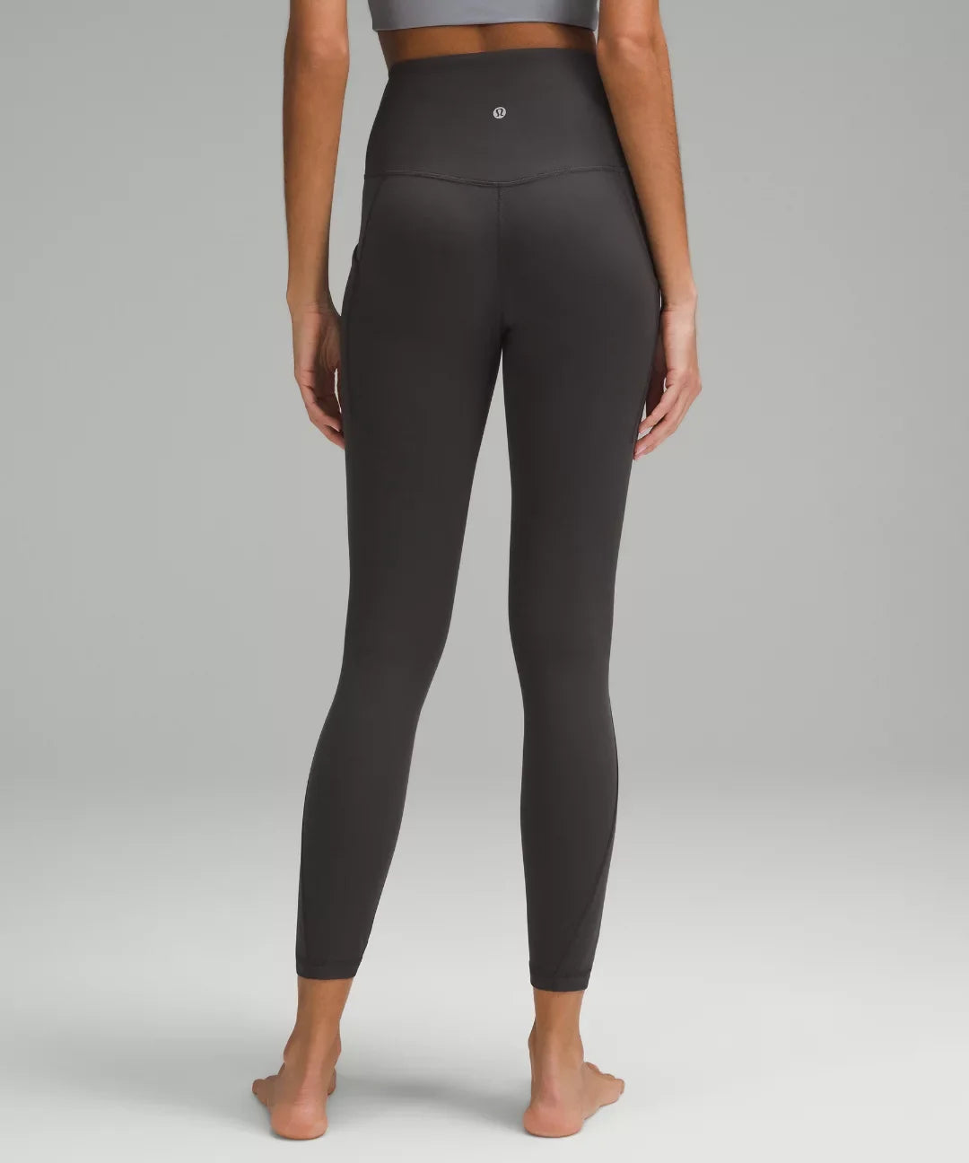 Person wearing black leggings on a plain background