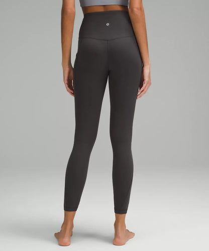 Person wearing black leggings on a plain background