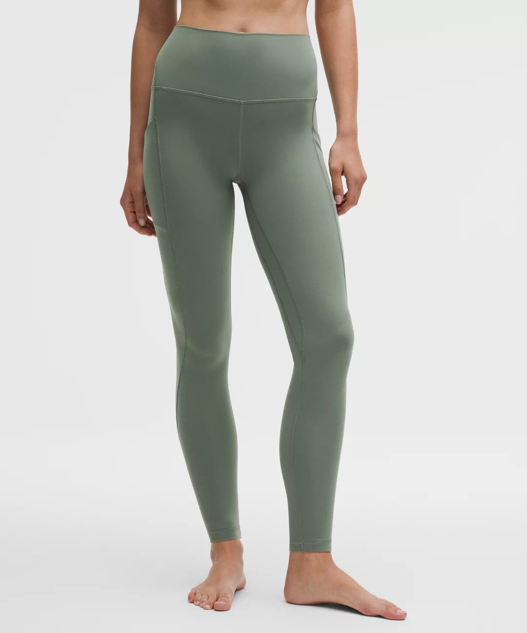 Person wearing green leggings on a white background