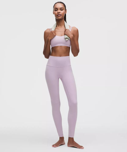 Woman wearing a light purple athletic outfit on a white background