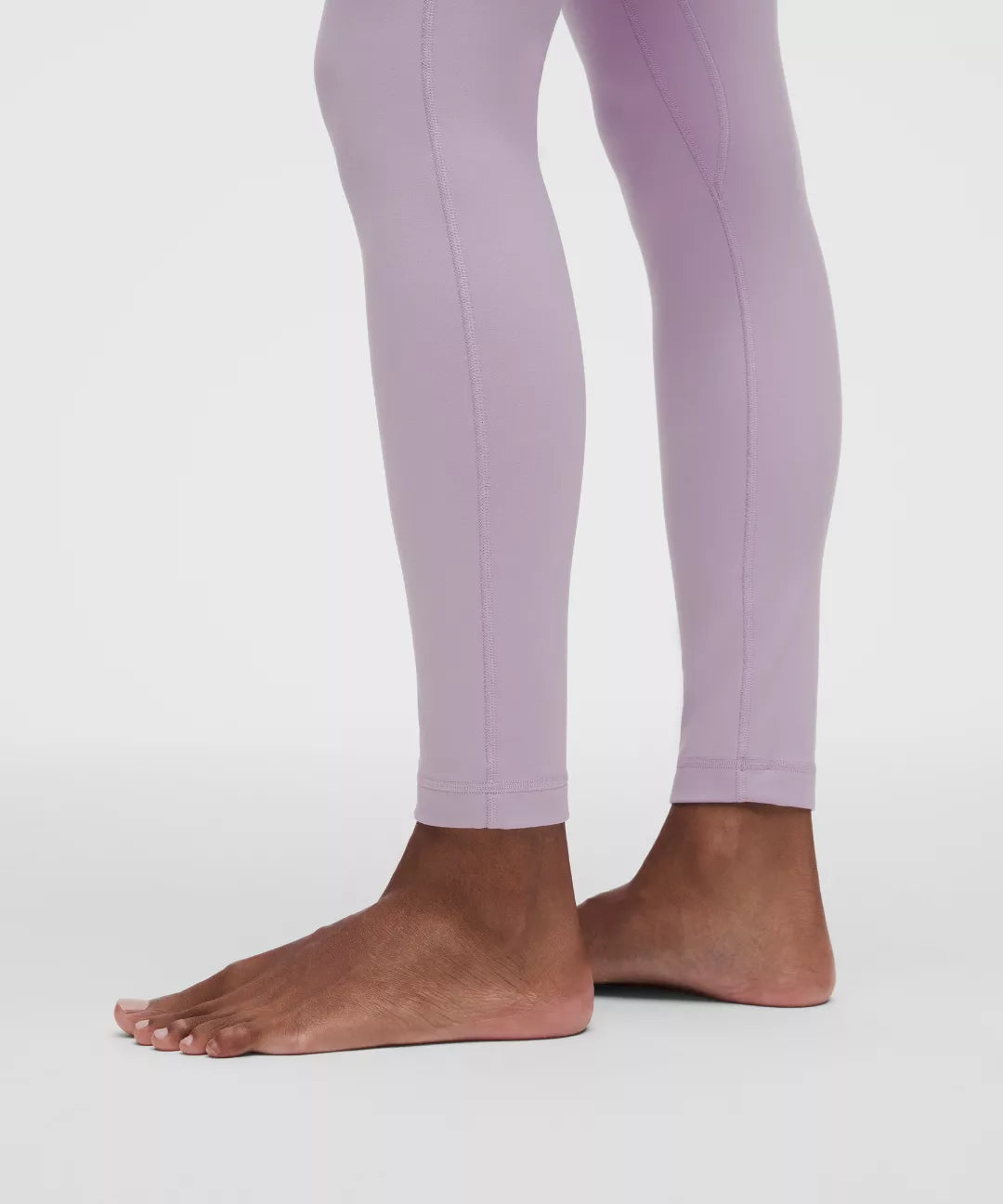 Purple leggings worn by a person on a white background