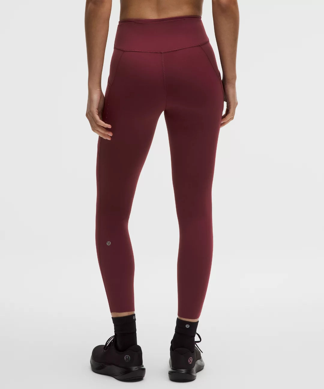 Maroon leggings worn by a person on a white background